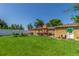 Spacious backyard featuring a large lawn, patio, and charming pergola-covered outdoor dining area at 17450 E 14Th Dr, Aurora, CO 80011