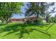 Serene backyard featuring lush green lawn, mature trees providing shade, and a relaxing hammock at 17450 E 14Th Dr, Aurora, CO 80011