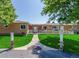 Charming single-story home with a welcoming entrance, beautiful lawn, and decorative pathway accents at 17450 E 14Th Dr, Aurora, CO 80011