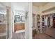 Hallway leading to bathroom with glass shower and double sink vanity; walk-in closet to the right at 6617 S Reed Way # C, Littleton, CO 80123