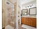Bathroom featuring glass-enclosed shower and double vanity sinks at 6617 S Reed Way # C, Littleton, CO 80123