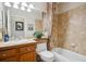 Bright bathroom featuring a shower-tub combo, single sink vanity, and neutral colored wall tiles at 6617 S Reed Way # C, Littleton, CO 80123