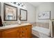 Well-lit bathroom showcasing a double vanity, a tub, and decorative accents at 6617 S Reed Way # C, Littleton, CO 80123
