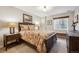 Comfortable bedroom featuring a patterned bedspread, dark wood furniture, and a bright window at 6617 S Reed Way # C, Littleton, CO 80123