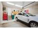 Spacious garage with a vehicle, storage, and stairs leading to an entry door at 6617 S Reed Way # C, Littleton, CO 80123