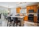 Bright kitchen featuring wooden cabinetry, stainless steel appliances, and island with seating at 6617 S Reed Way # C, Littleton, CO 80123