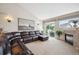 Spacious living room with a large sectional sofa, a modern fireplace, and sliding doors to the backyard, flooded with light at 6617 S Reed Way # C, Littleton, CO 80123