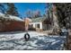 View of home's back exterior, snowy yard, and tire swing at 3750 S Ogden St, Englewood, CO 80113