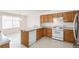 Kitchen with oak cabinets, white appliances, and breakfast bar at 9691 Independence Dr, Westminster, CO 80021