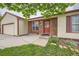 Charming home with a brick entryway, colorful front door, and a lush green lawn at 18240 E Mexico Pl, Aurora, CO 80017