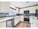 Bright kitchen with white cabinetry, stainless steel appliances, and a stylish tile backsplash at 18240 E Mexico Pl, Aurora, CO 80017