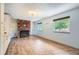 Bright living room with wood floors, brick fireplace, built-in shelving, and natural light from two windows at 18240 E Mexico Pl, Aurora, CO 80017