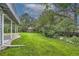 Lush backyard with a well-maintained lawn, mature trees, and a covered patio area at 1013 E 130Th Dr, Thornton, CO 80241