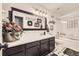 Charming bathroom boasts a large mirror, stylish vanity, fresh decor, and a tub-shower combo with glass door at 1013 E 130Th Dr, Thornton, CO 80241