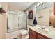 Practical bathroom with a shower/tub combo, a sink vanity, white tiling, and neutral-colored walls at 1013 E 130Th Dr, Thornton, CO 80241
