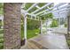 Inviting front porch with a white pergola, brick accents, and lush greenery provides a charming outdoor space at 1013 E 130Th Dr, Thornton, CO 80241