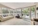 Cozy sun room with plush couch, large windows, and sliding doors leading to a deck at 1013 E 130Th Dr, Thornton, CO 80241