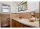 Bathroom with brown tile, wood vanity, and a large mirror at 1000 Collyer St, Longmont, CO 80501