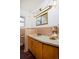 Retro bathroom with wood vanity, updated sink, and tiled shower at 1000 Collyer St, Longmont, CO 80501