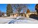 Ranch home with attached garage and a snow-covered front yard at 1000 Collyer St, Longmont, CO 80501