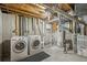 Unfinished basement with washer, dryer, and utility appliances offer functionality and potential at 2910 S Racine St, Aurora, CO 80014