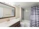 Stylish bathroom featuring gray tile, a tub-shower combo, a dark vanity and striped shower curtain at 2910 S Racine St, Aurora, CO 80014