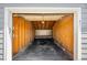 Empty one-car garage with wooden walls and an attached door at 2910 S Racine St, Aurora, CO 80014
