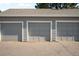Three car garage on a paved road with light-grey doors at 2910 S Racine St, Aurora, CO 80014