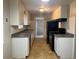 Updated kitchen featuring tile floors, white cabinets, and modern appliances with an open view into the living area at 4785 Estes St, Wheat Ridge, CO 80033