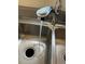 Close-up of a stainless steel kitchen sink with a modern faucet and running water with a black garbage disposal at 4785 Estes St, Wheat Ridge, CO 80033