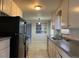 Well-lit kitchen features tile floors, white cabinets, and modern appliances with an open view into another room at 4785 Estes St, Wheat Ridge, CO 80033