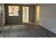 Cozy living room with fresh gray carpet, neutral walls, and an opening providing a glimpse into the well-lit kitchen at 4785 Estes St, Wheat Ridge, CO 80033