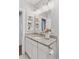 Well-lit bathroom with granite vanity and shelves for storage at 3976 S Washington St, Englewood, CO 80113