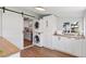 Bright laundry room features stacked washer/dryer, wood countertops and sliding barn door at 3976 S Washington St, Englewood, CO 80113