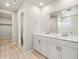 Modern bathroom with double vanity, wood-look floors, and glass-enclosed shower for a spa-like experience at 559 Homestead Ave, Brighton, CO 80601