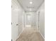 Light-filled hallway with plush carpet, neutral walls, and multiple doorways leading to various rooms at 559 Homestead Ave, Brighton, CO 80601