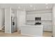 Open-concept kitchen featuring white cabinets, a center island, stainless steel appliances, and a modern design at 559 Homestead Ave, Brighton, CO 80601