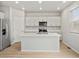 Bright kitchen features a large island, stainless steel appliances, and white cabinets at 559 Homestead Ave, Brighton, CO 80601