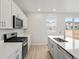 Bright kitchen with gas range, island sink, and stainless steel appliances at 559 Homestead Ave, Brighton, CO 80601