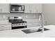 Modern kitchen boasts stainless steel appliances, gas range, and sleek countertops at 559 Homestead Ave, Brighton, CO 80601