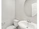 Neat powder room features a pedestal sink with a circular mirror and a modern faucet at 559 Homestead Ave, Brighton, CO 80601