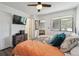 Bright bedroom with mounted TV, modern decor and a large window overlooking the neighborhood at 1830 Newland Ct # 101, Lakewood, CO 80214