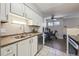 Bright kitchen featuring stainless steel appliances and dining space with dark flooring at 1830 Newland Ct # 101, Lakewood, CO 80214