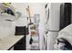 A functional laundry area with a stacked washer/dryer unit and storage at 1830 Newland Ct # 101, Lakewood, CO 80214