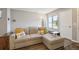 Comfortable living room area with lots of natural light, a large couch with colorful pillows, and durable laminate flooring at 1830 Newland Ct # 101, Lakewood, CO 80214