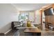 Cozy living room featuring hardwood floors, a comfortable sectional couch, and access to the entryway and kitchen at 1830 Newland Ct # 101, Lakewood, CO 80214