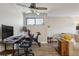Bright and open living room featuring laminate flooring, a ceiling fan, and a dedicated area for office and fitness at 1830 Newland Ct # 101, Lakewood, CO 80214