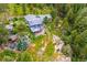 Aerial view of the property highlighting the outdoor deck, mature landscaping, and natural surroundings at 6565 Marshmerry Ln, Evergreen, CO 80439