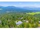 Overhead shot of a wooded home showcasing lush greenery and mountain views at 6565 Marshmerry Ln, Evergreen, CO 80439