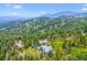 Breathtaking aerial perspective of a home surrounded by towering trees and mountains, offering serenity and unparalleled views at 6565 Marshmerry Ln, Evergreen, CO 80439